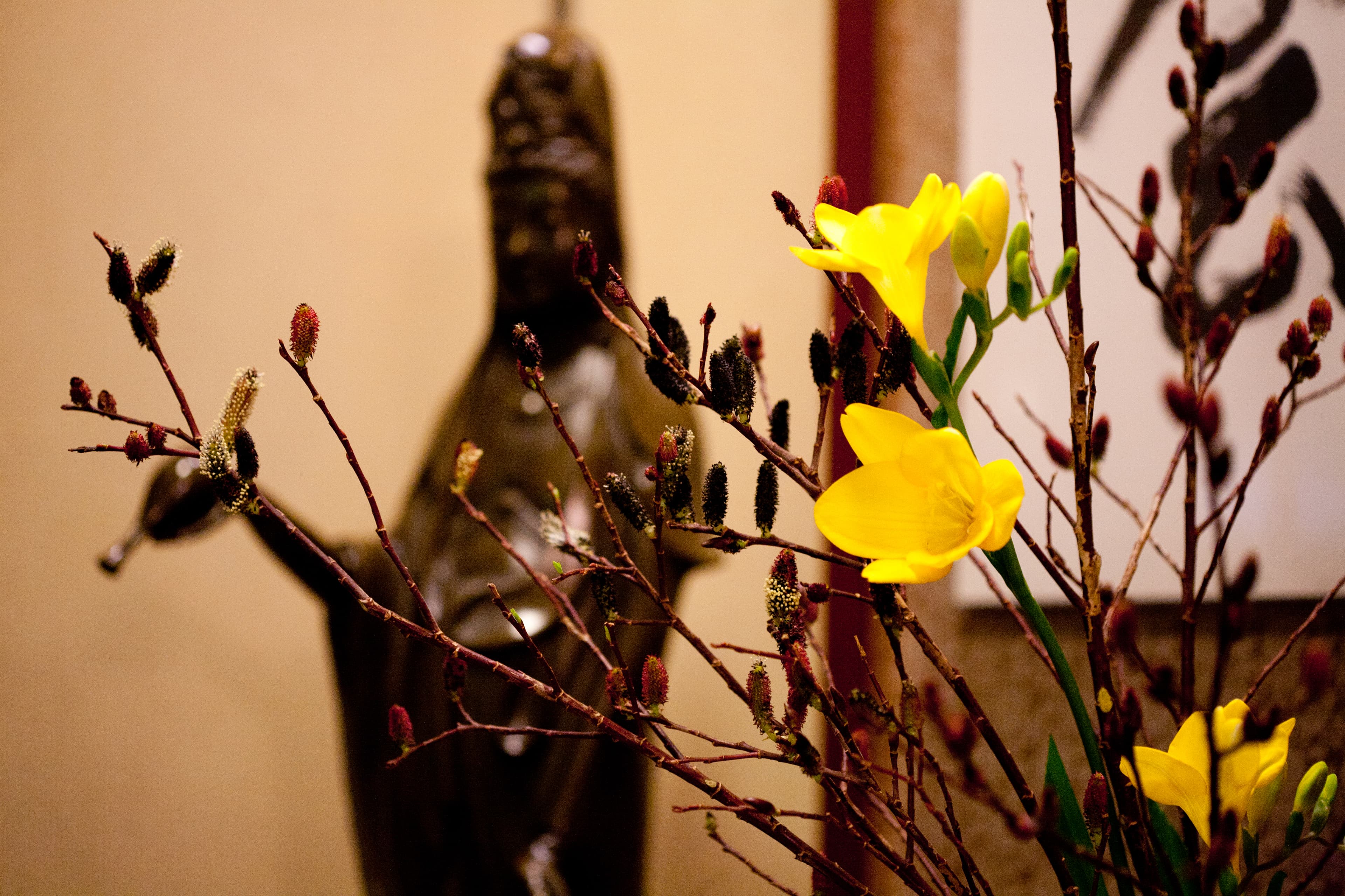 Atmospheric detail at Kimi Ryokan with yellow freesia blossoms before a bronze Kannon statue
