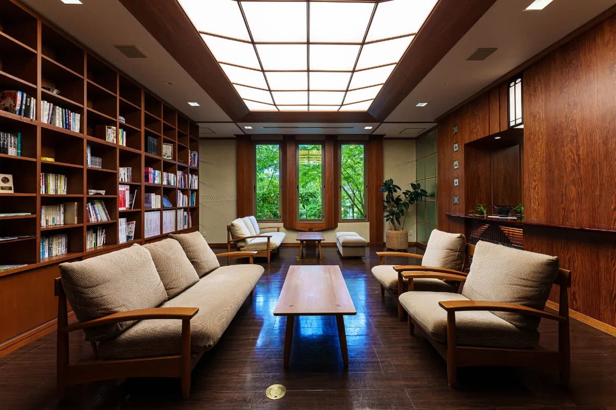 Wood-panelled library lounge with sofas and bookshelves at Ryotei Hanzuiryo