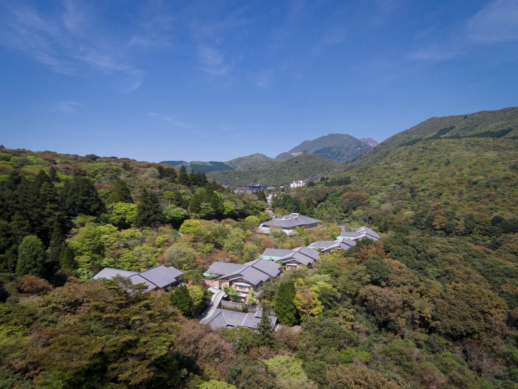 Aerial view of Ryotei Hanzuiryo's villa rooftops nestled in the forested Unzen mountains