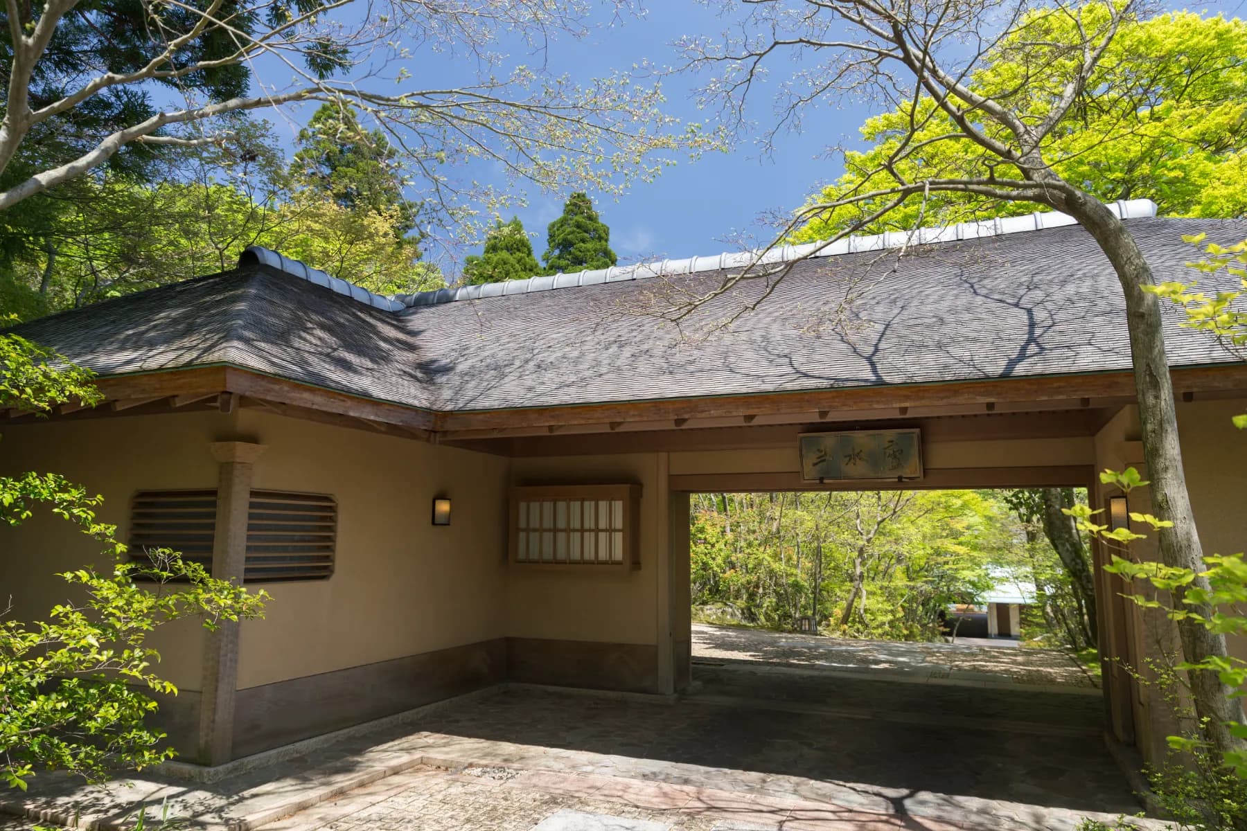 Thatched-roof entrance gatehouse of Ryotei Hanzuiryo amid maples, Unzen Onsen, Nagasaki