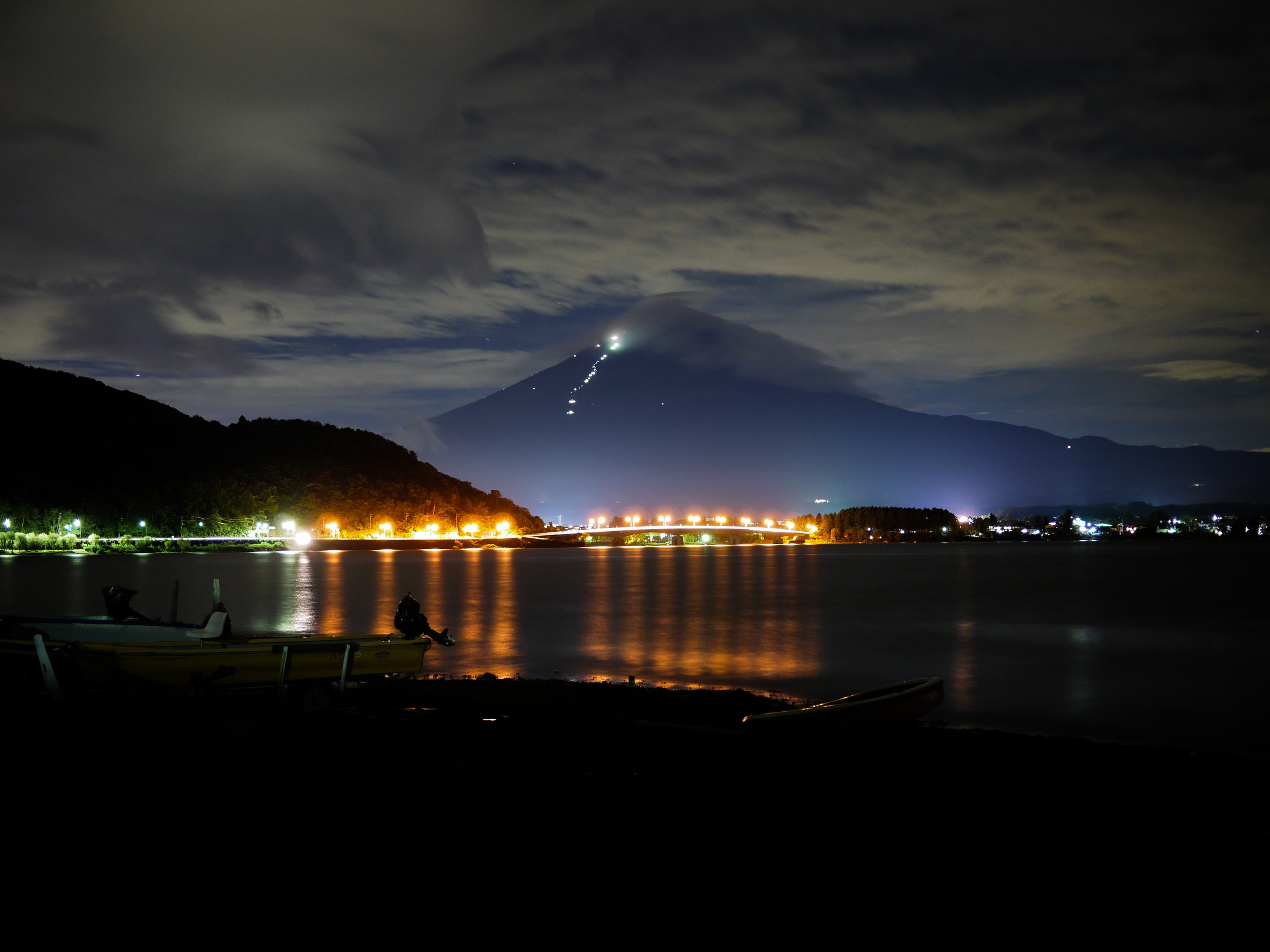 Lake Kawaguchi at dawn with Mt. Fuji reflected in still water — the view from north-shore ryokans