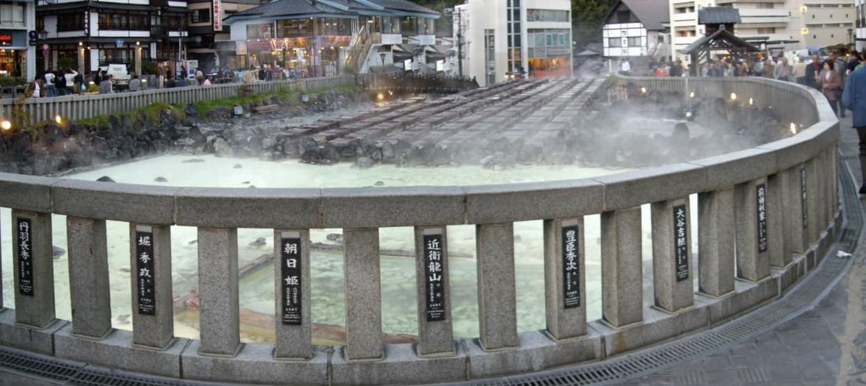 Kusatsu Yubatake — the iconic hot water field at the centre of Kusatsu Onsen in Gunma, where pH 2.1 acidic-sulfur water cools through wooden channels before reaching the bathhouses