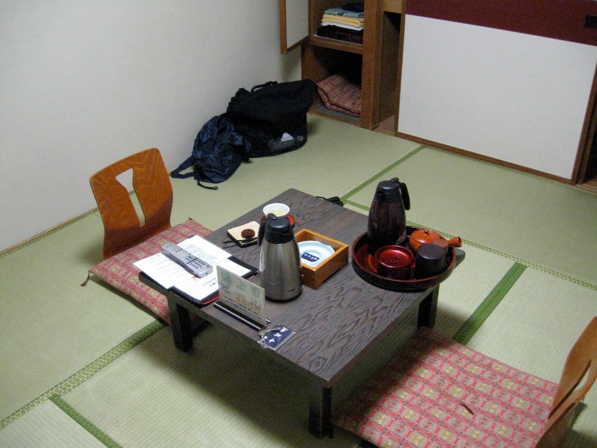 A calm traditional ryokan room with clean lines and natural materials, the kind of unhurried space where older parents can rest between baths and meals