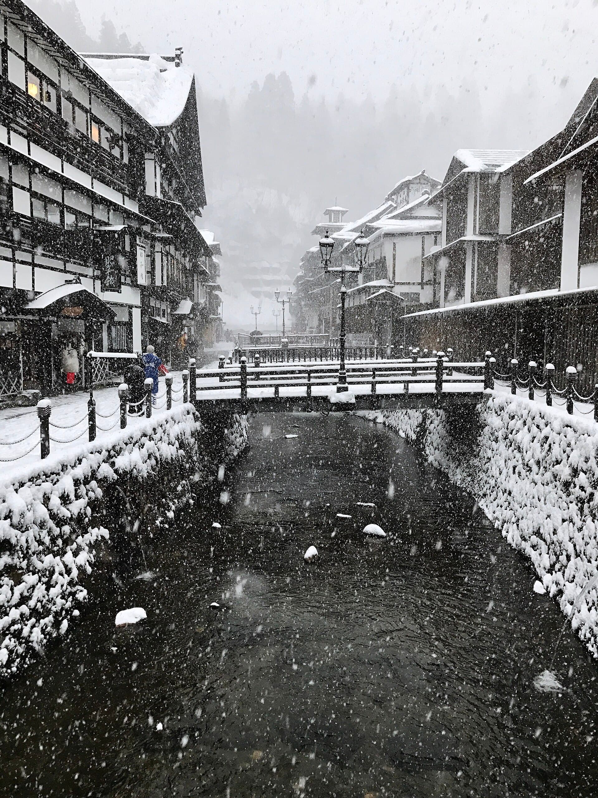 Aerial view of Ginzan Onsen valley with ryokan buildings lining both banks of river