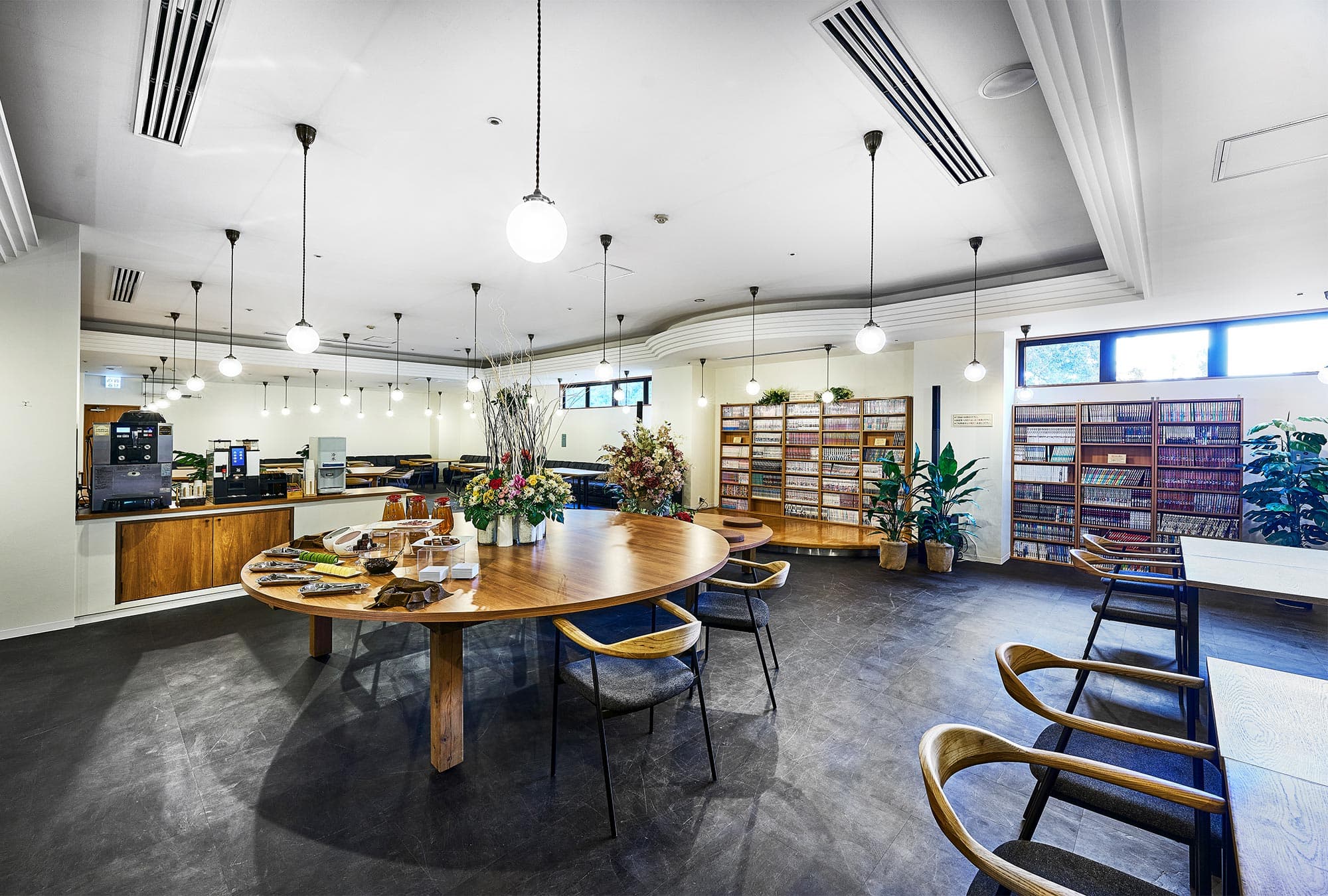 Rantei Club Lounge Orchid guest-exclusive free lounge with wooden round table pendant lighting and curated bookshelves