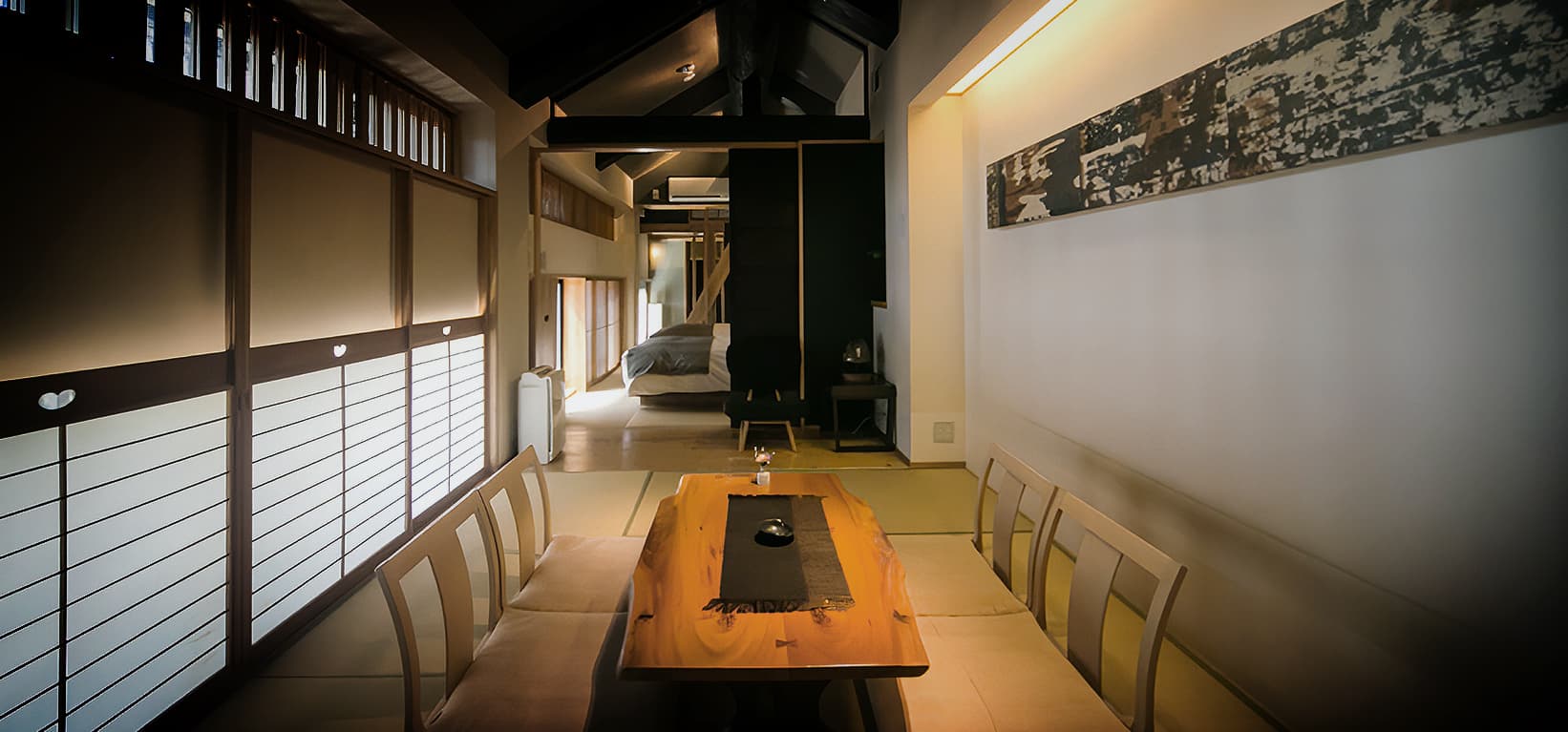 Long live-edge dining table flanked by chairs in a townhouse-style villa interior at CHAHARU Hanare Dogo Yumekura