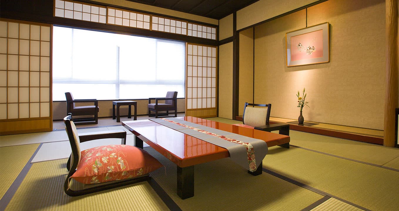 Traditional tatami guest room at Ryokan Kanazawa Chaya with a red lacquer low table, shoji screens and tokonoma alcove