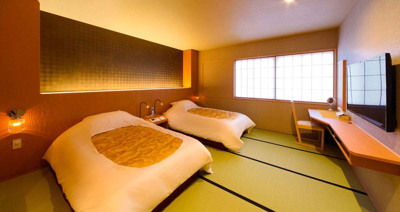 Modern Japanese-style twin-bed guest room with tatami flooring and shoji windows at Ryokan Kanazawa Chaya