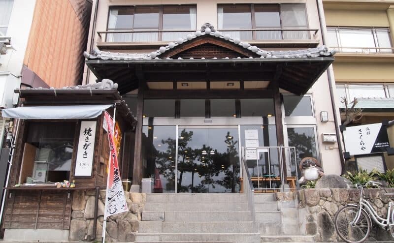 Entrance of Sakuraya on Miyajima, a tiled gable porch above stone steps