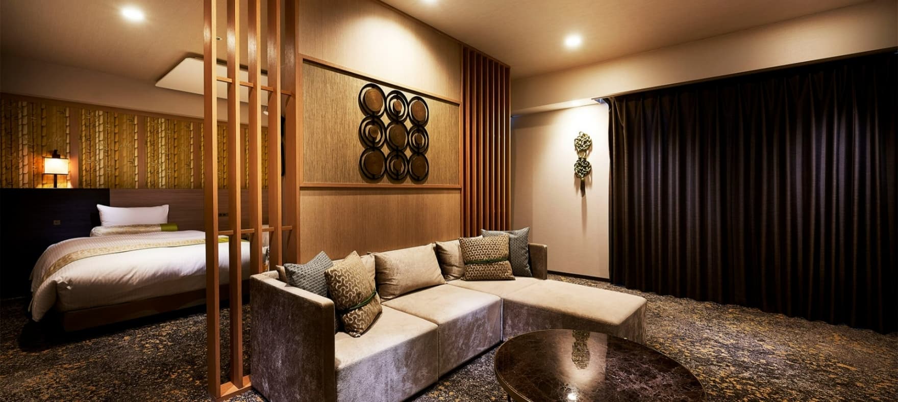 Suite lounge with a plush sofa, low round table and a partitioned bed area in muted tones at Daiwa Roynet Hotel Nara