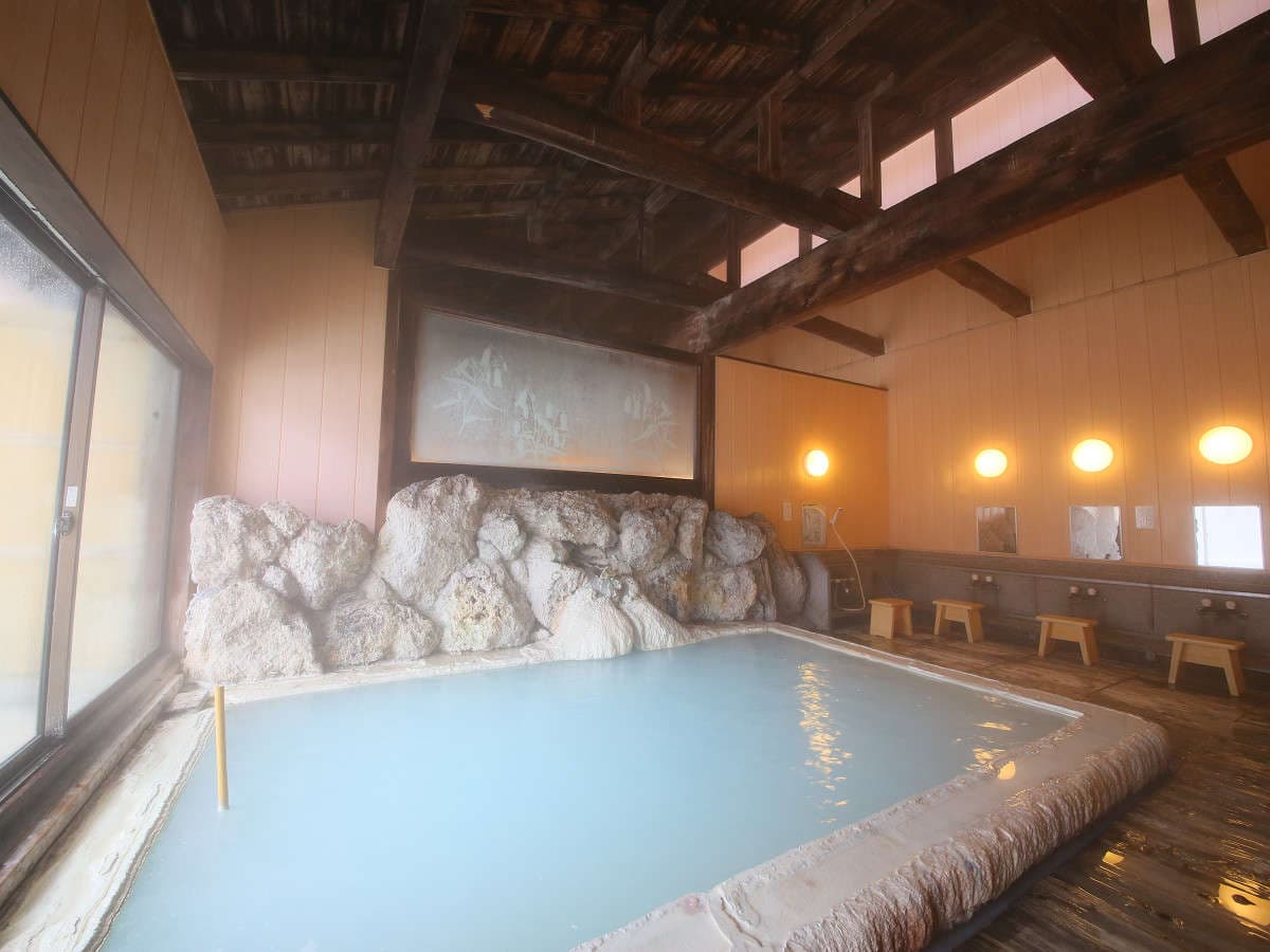 Steaming indoor milky-white sulfur bath with natural rock surround at Shirahone Ebisuya, Shirahone Onsen