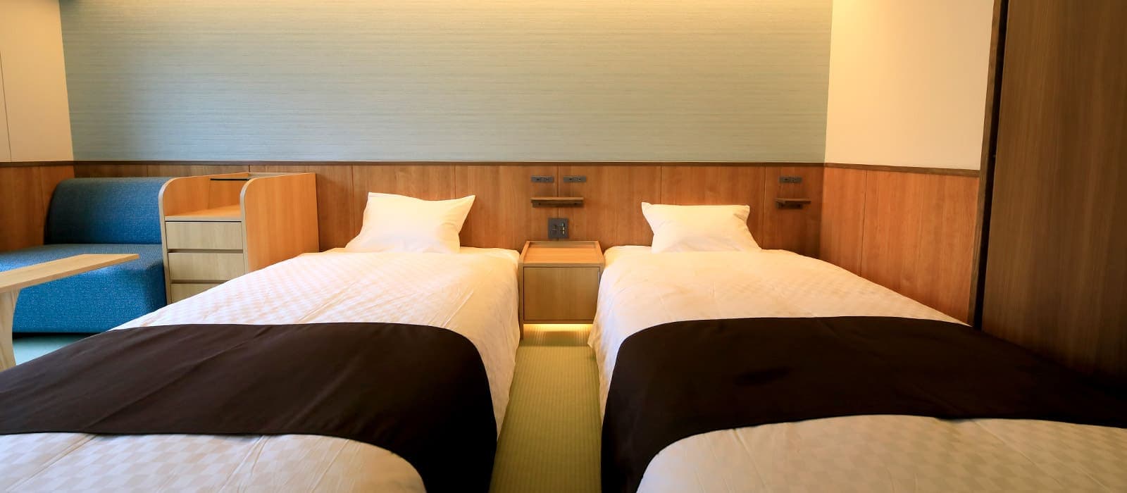 Modern twin guest room with two beds, wood paneling and tatami floor