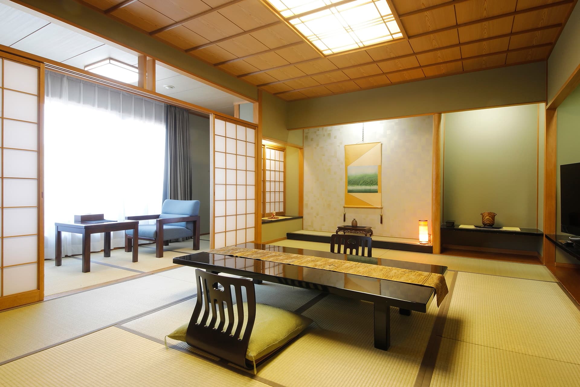 Spacious tatami guest room at Miyukiso Hanamusubi with low lacquered table, shoji screens and a tokonoma alcove