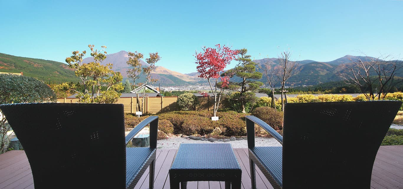 Garden terrace at Yufuin Hanayoshi with an autumn maple and Mount Yufu in the distance