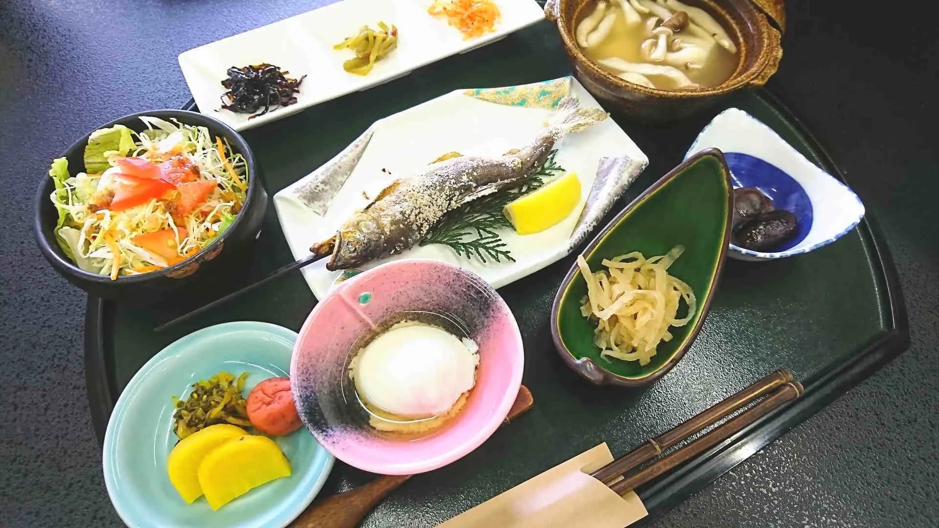 Japanese breakfast tray with rice, grilled fish and small side dishes at Ichinoi