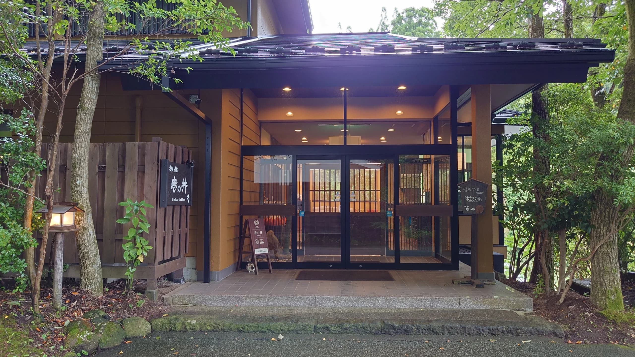 Ryokan Ichinoi traditional wooden building exterior amid the forested hillside of Kurokawa Onsen