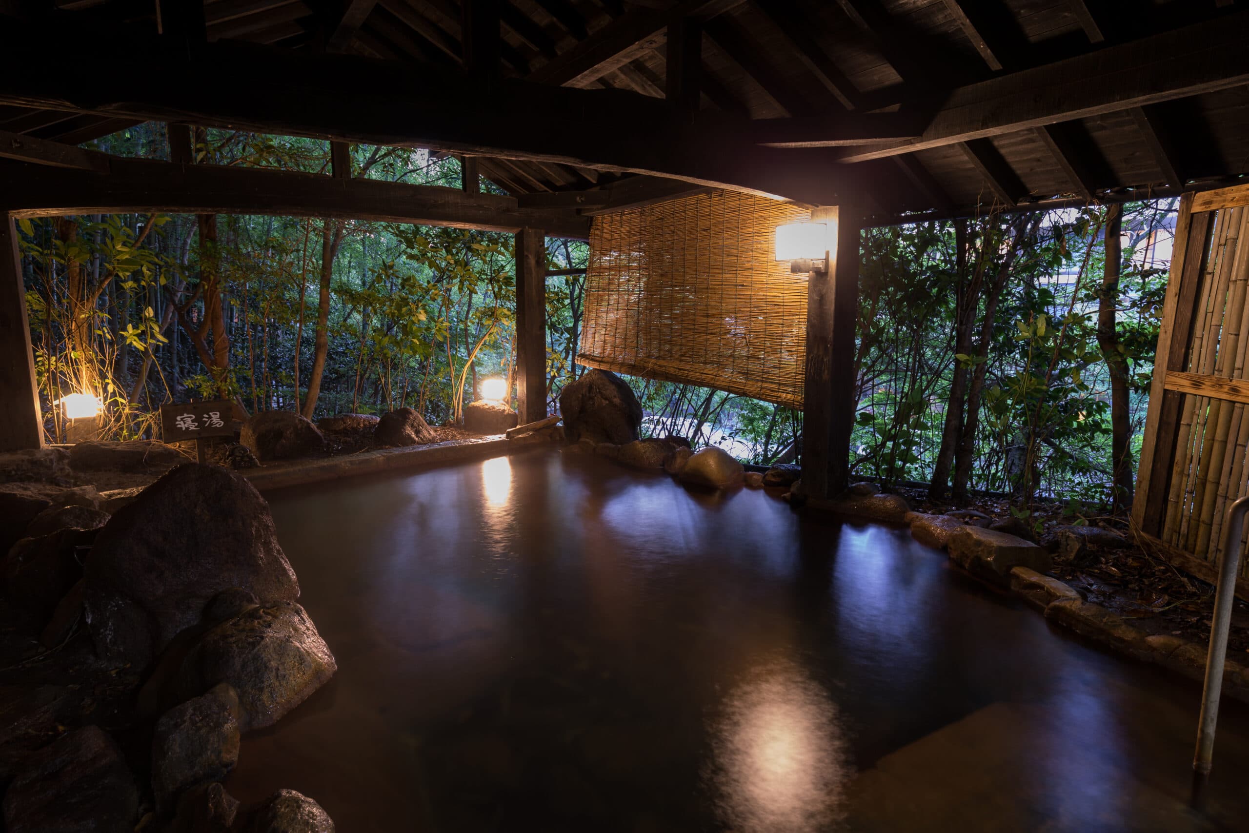 Ryokan Wakaba open-air rotenburo hot spring under a wooden roof surrounded by bamboo, Kurokawa Onsen