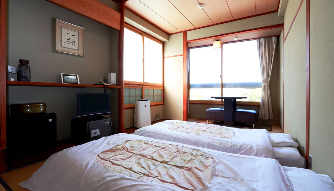 Cozy Japanese-style tatami guest room with futon bedding and a tokonoma alcove at Yamaichi Bekkan, Miyajima