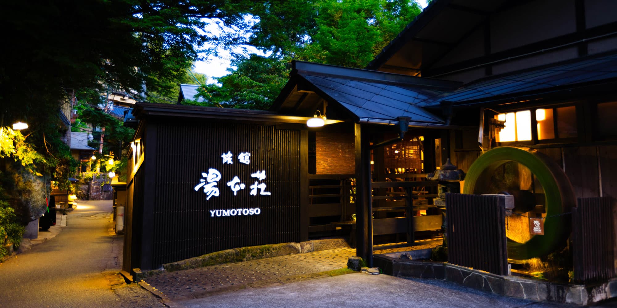 Ryokan Yumotoso main building exterior at dusk with glowing lanterns, Kurokawa Onsen